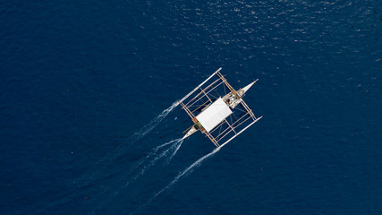 Wall Mural - Aerial top down view of boat moving in open sea with clear and turquoise water on over coral reef,  Boat left the tropical lagoon, Moalboal, Oslob, Cebu Island, Philippines.