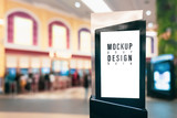 Fototapeta  - Mockup blank empty advertising light box for your advertisement artwork, text or media content with blurred image of ticket sales counter at movie theater. Mock up concept for advertisement marketing
