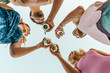 Group of happy friends drinking and toasting beer outdoors at the beach - Friendship concept with young people having fun together at summer pub - view from the bottom with sky background