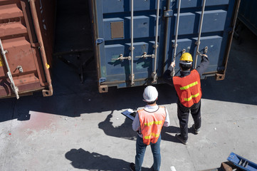 Foreman control loading containers box from cargo freight ship for import export, Foreman control industrial container cargo freight ship, Business import and export logistic concept.