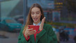 Smiling young woman uses phone in the city center on Christmas time happy internet mobile adult caucasian cellphone street urban winter young attractive beautiful cell slow motion
