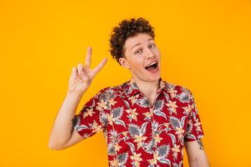 Poster - Image of caucasian delighted man smiling and gesturing peace sign