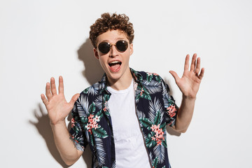 Poster - Image of young excited man in sunglasses expressing surprise at camera