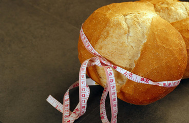 Wall Mural - tape measure wrapped in a large bread, bread weighs weight, diet and bread,