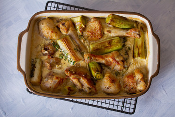 Wall Mural - Chicken thighs and legs in sour cream sauce with leek and thyme. Overhead horizontal image