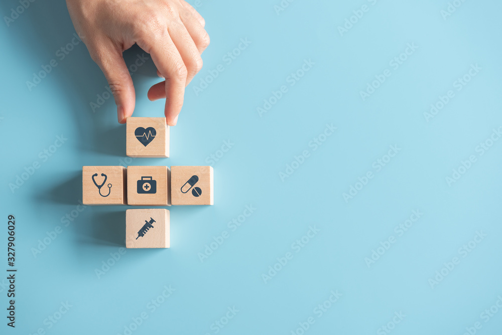 Health Insurance Concept, Hand of woman arranging wood cube stacking with icon healthcare medical on blue background, copy space. - obrazy, fototapety, plakaty 