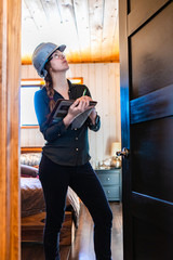 Wall Mural - worker woman wears a grey hard hat look up. female construction inspector reviews a room door during home inspection as she holding clipboard.