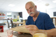© auremar - senior man reading menu in restaurant