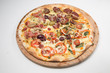 © christian vinces - Salami pizza with mushrooms, onions, green olives  and tomato with white background