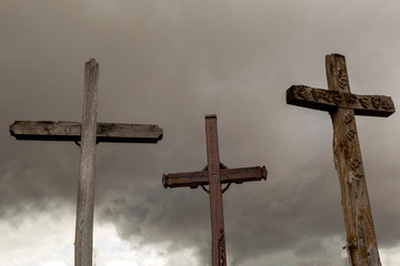 Three religious crosses with a dark scary sky on the background.