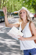 © auremar - woman holding map hailing for a taxi