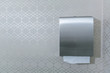 silver metal paper towel bathroom dispenser on an elegant white gray wallpaper patter that is simple and timeless