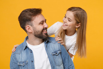 Wall Mural - Funny bearded man in casual clothes have fun with cute child baby girl. Father little kid daughter isolated on yellow background. Love family day parenthood childhood concept. Looking at each other.