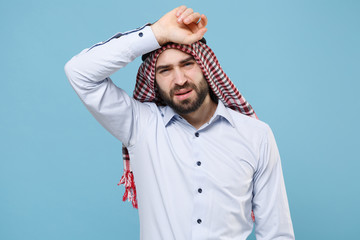 Wall Mural - Tired young bearded arabian muslim man in keffiyeh kafiya ring igal agal casual clothes isolated on pastel blue background. People religious lifestyle concept. Mock up copy space. Put hand on head.