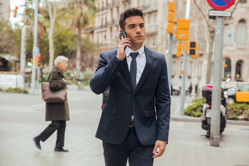 Wall Mural - boy walking with blue suit and calling by phone in city