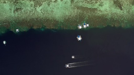 Wall Mural - Aerial top down view of boat moving in open sea with clear and turquoise water on over coral reef,  Boat left the tropical lagoon, Moalboal, Oslob, Cebu Island, Philippines, 4K.