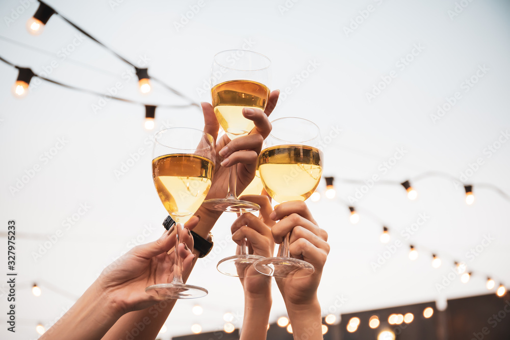 Group of people in party and celebrating together with white wine. Happy Asian people enjoy partying in festival and celebrate with white wine on the roof top bar and restaurant of 5 stars hotel. - obrazy, fototapety, plakaty 
