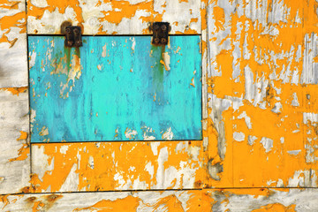 Wall Mural - Close up old peeled yellow and blue colored wooden wall and window detail of building exterior