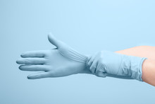 Female Doctor's Hands Putting On Blue Sterilized Surgical Gloves
