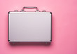 Contemporary aluminum briefcase on pink background. Flat lay concept.