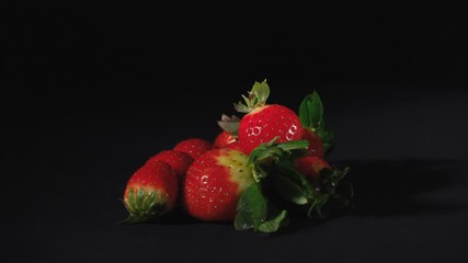 Wall Mural - Video of rotating sweet strawberry on black background