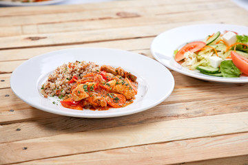 Wall Mural - meat with buckwheat and salad on the wooden background