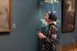 A woman in a museum listens to an audio guide