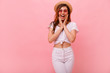 © ClaudiK - Photo of young surprised beautiful woman standing isolated over pink background. Looking camera.