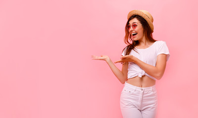 Wall Mural - Image of happy young lady standing isolated over pink background. Looking camera pointing.Photo of happy young woman standing isolated over pink wall background. Looking camera showing copyspace.