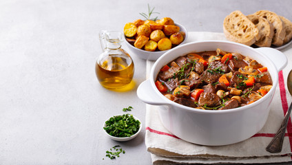 Wall Mural - Beef bourguignon stew with vegetables. Grey background. Copy space.