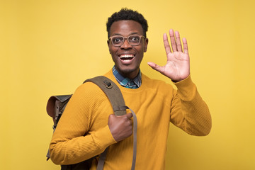 Canvas Print - Young african american welcoming student man showing five fingers at camera