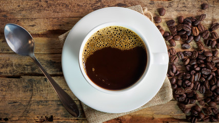 Wall Mural - Coffee cups and coffee beans roasted on a wooden table