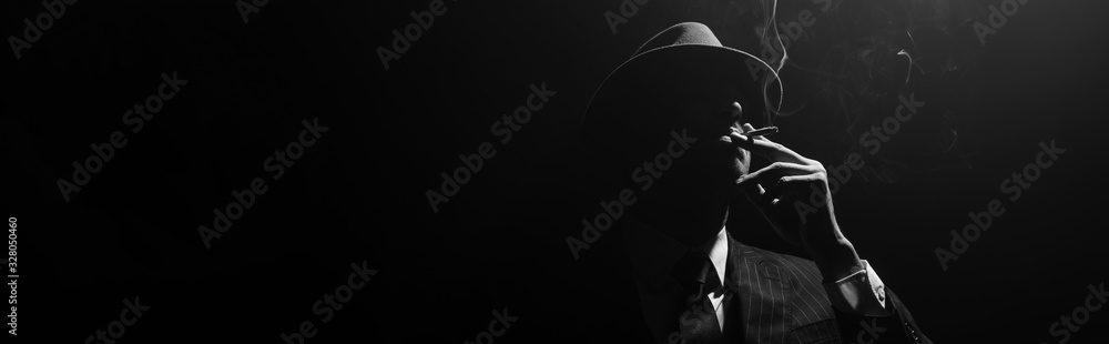 Monochrome image of mafioso silhouette smoking on black background, panoramic shot - obrazy, fototapety, plakaty 