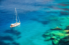 A Sailing Boat On Calm Sea On A Sunny Day In Deep Blue And Turquoise Waters In Zakynthos Greece