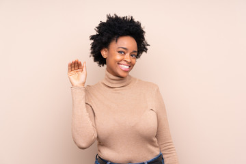 Wall Mural - African american woman over isolated background saluting with hand with happy expression