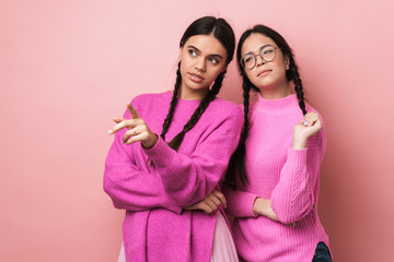 Wall Mural - Image of two young teenage girls pointing finger at copyspace