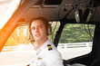 Portrait of young caucasian pilot with headset sitting in private airplane cabin flying.Handsome pilot in formal wear and headset sitting in helicopter cabin.Aircraft of transportation.