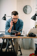© JustLife - Businessman in office. Handsome man talking on phone at work.