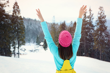 Wall Mural - Young woman at mountain resort, back view. Winter vacation