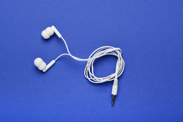 White earphones on blue background