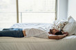 © PhotoAlto - Thoughtful Young man lying on bed in bedroom