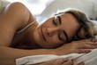 © PhotoAlto - Close-up of young woman sleeping peacefully on bed in bedroom