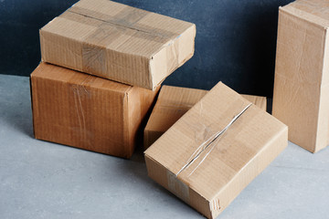 Cardboard boxes sealed with adhesive tape isolated on a black gray wall background