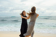 © Sibstock/Stocksy - two young girl friends having fun on the ocean. holding hands and swirling in the sand