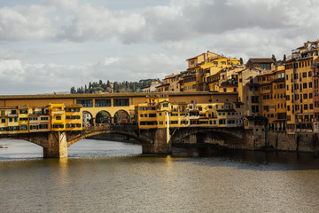 Ponte Vecchio with river Arno in sunny spring day in Florence, Italy. Ponte Vecchio - famous old bridge in Florence on the Arno river, Italy.