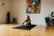 © Flamingo Images/Stocksy - Little girl stretching on mat