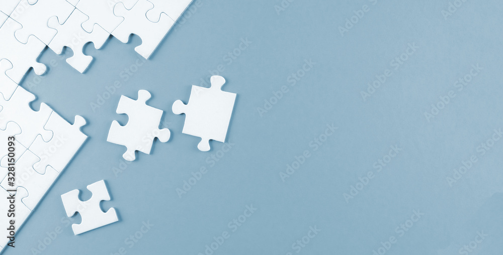 top view of white blank unfinished jigsaw puzzle on blue background, completing a task or solving a problem concept - obrazy, fototapety, plakaty 