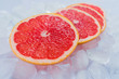© Olivka888 - Pieces of grapefruit lie on ice cubes. Close-up.