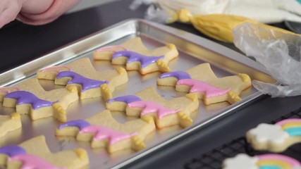 Sticker - Step by step. Decorating unicorn sugar cookies with royal icing on baking sheet.