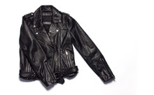 Black women's leather jacket on white background top view. Fashionable modern trendy women's clothing. Vintage biker jacket. Black genuine leather